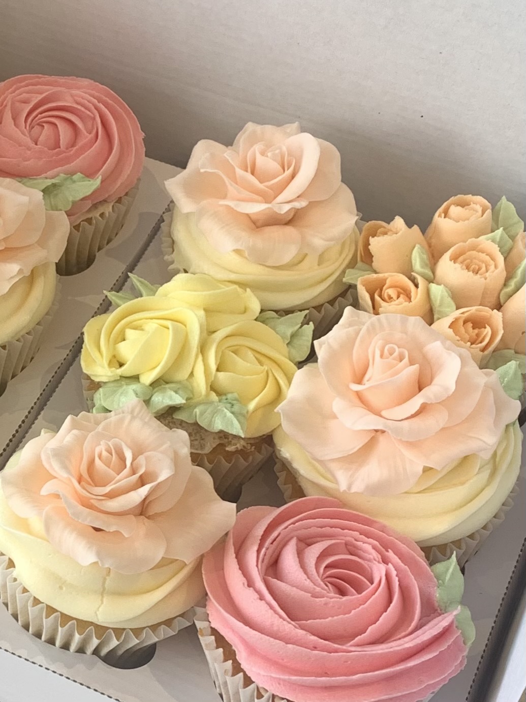 Pretty cupcakes with peach handmade sugar roses, piped buttercream roses and buttercream flowers
