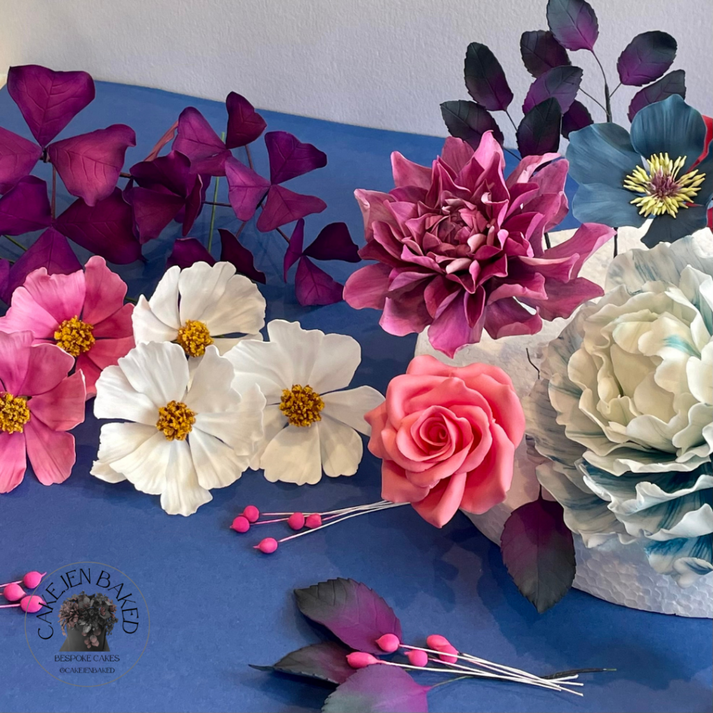 pink and white sugar cosmos
pink dahlia
blue hellebore
purple oxalis 
pink rose
handmade sugar flowers