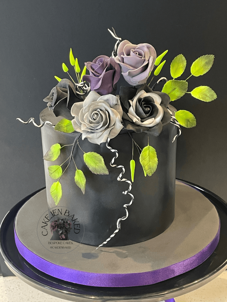 Beetlejuice inspired floral cake. Black cake with sugar roses in grey, black, lilac and purple. With neon green leaves and buds