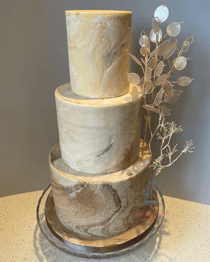three tier cake with brown and beige stone effect sugar paste with marble colouring. Decorated with handmade dried flowers including queen anne's lace and honesty