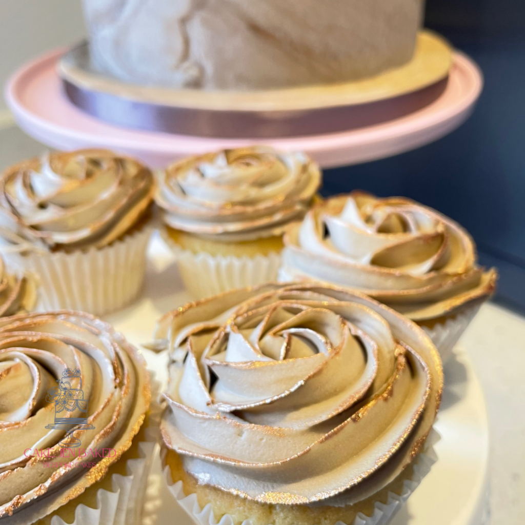 beige cupcakes with a rose swirl and metallic gold details