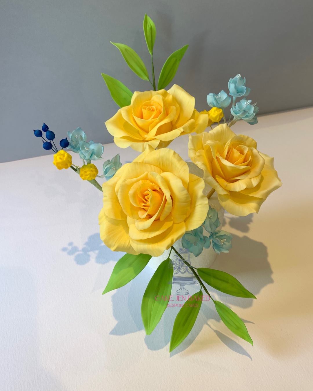 Yellow sugar roses arranged with foliage and berries