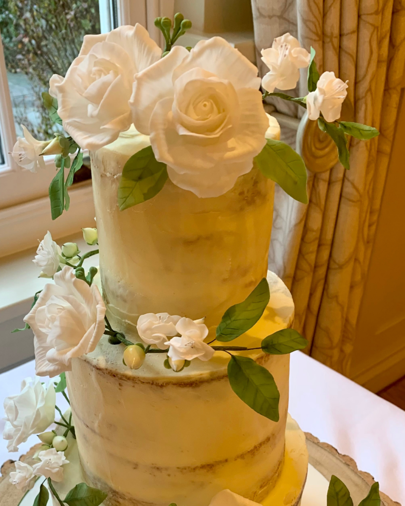 three tier semi naked wedding cake with sugar roses