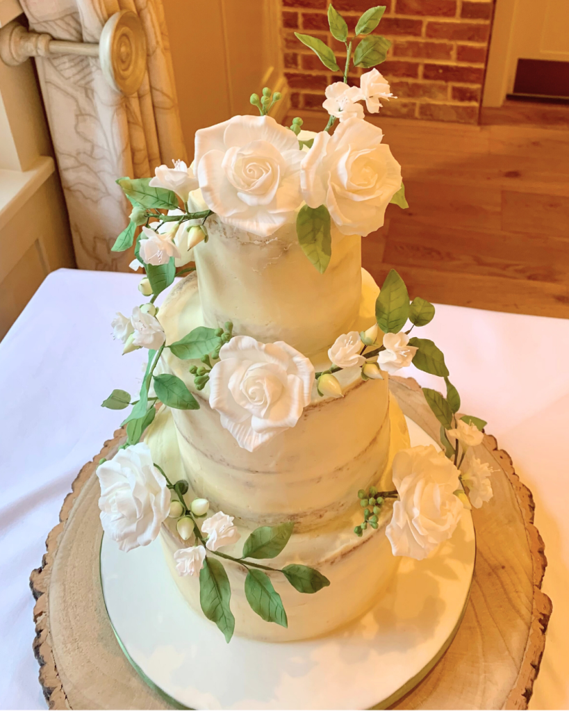 three tier semi naked wedding cake with handmade sugar flowers (roses)