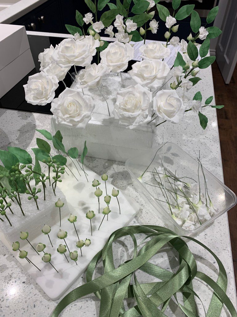 White sugar roses with berries and green leaves perfect for a winter wedding